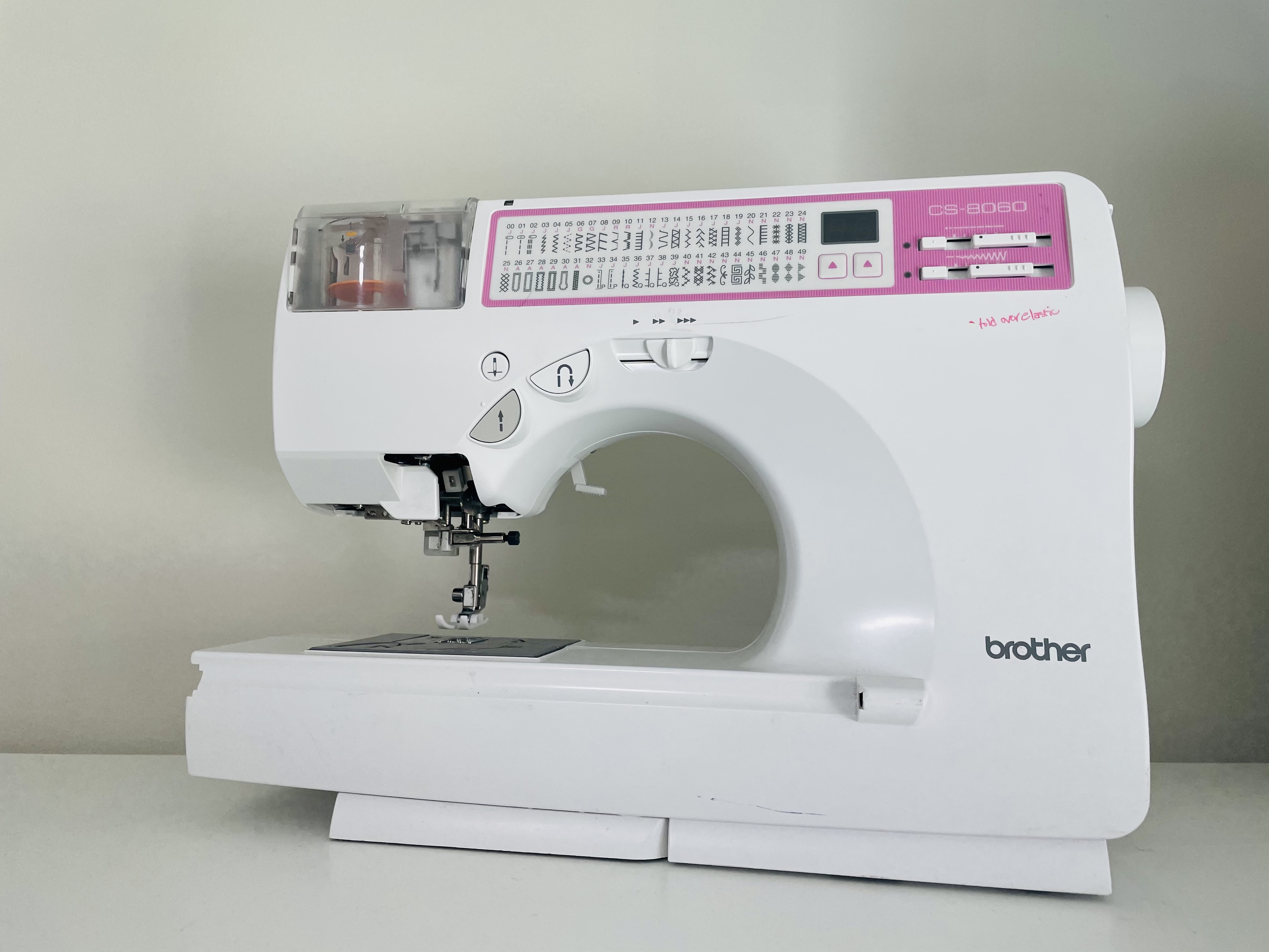 A brother CS 8060 sewing machine sits on a white surface