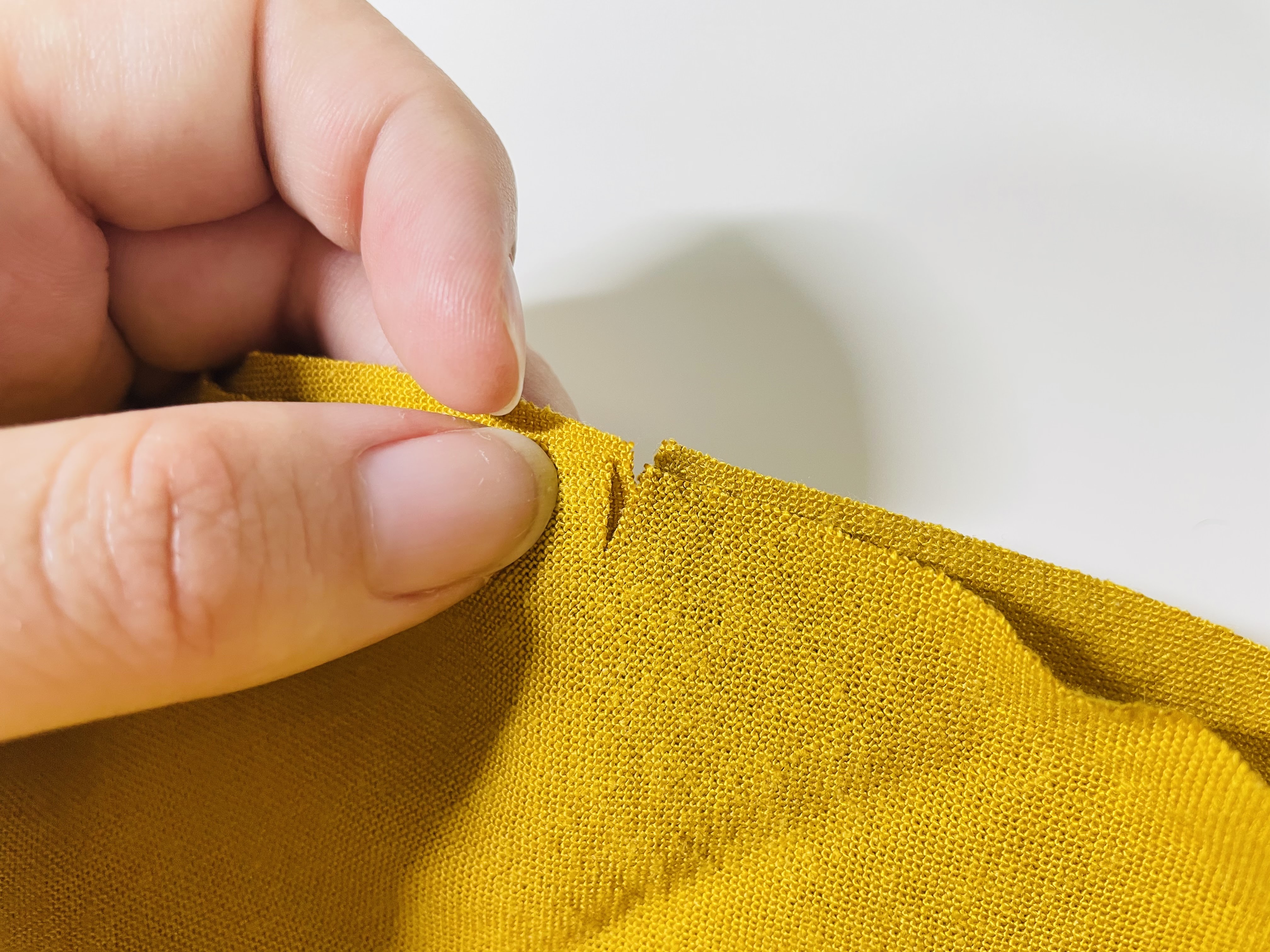 Lindsie holds two notched pieces of fabric together so that their notches align