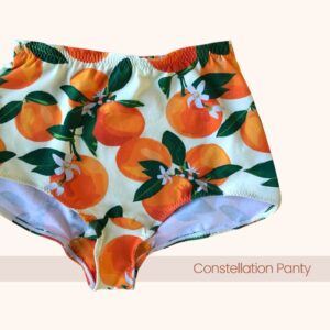 A front view of the Constellation Panty Pattern in an orange fruit pattern on cream fabric with the text “Constellation Panty”.