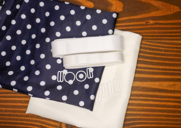 The Navy Polka Dot Satin Jet Set Kit features ivory polka dot pattern on navy satin fabric and a solid ivory satin fabric; white elastic; and white rings, g hooks, and sliders.